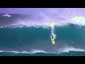 Humpback whale breaches behind surfer on giant wave