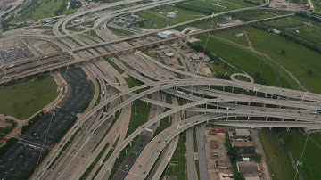 Aerial view of large and complex multilane highway intersection. Cars smoothly driving in lanes