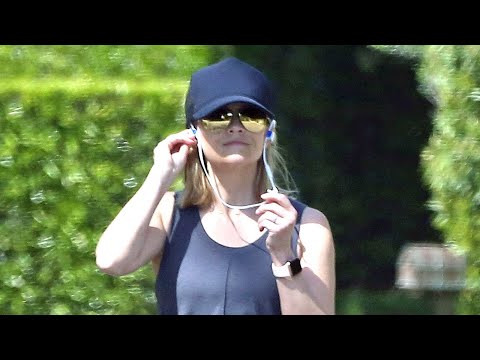 Reese Witherspoon out for a walk closely followed by her bodyguard in a SUV following behind