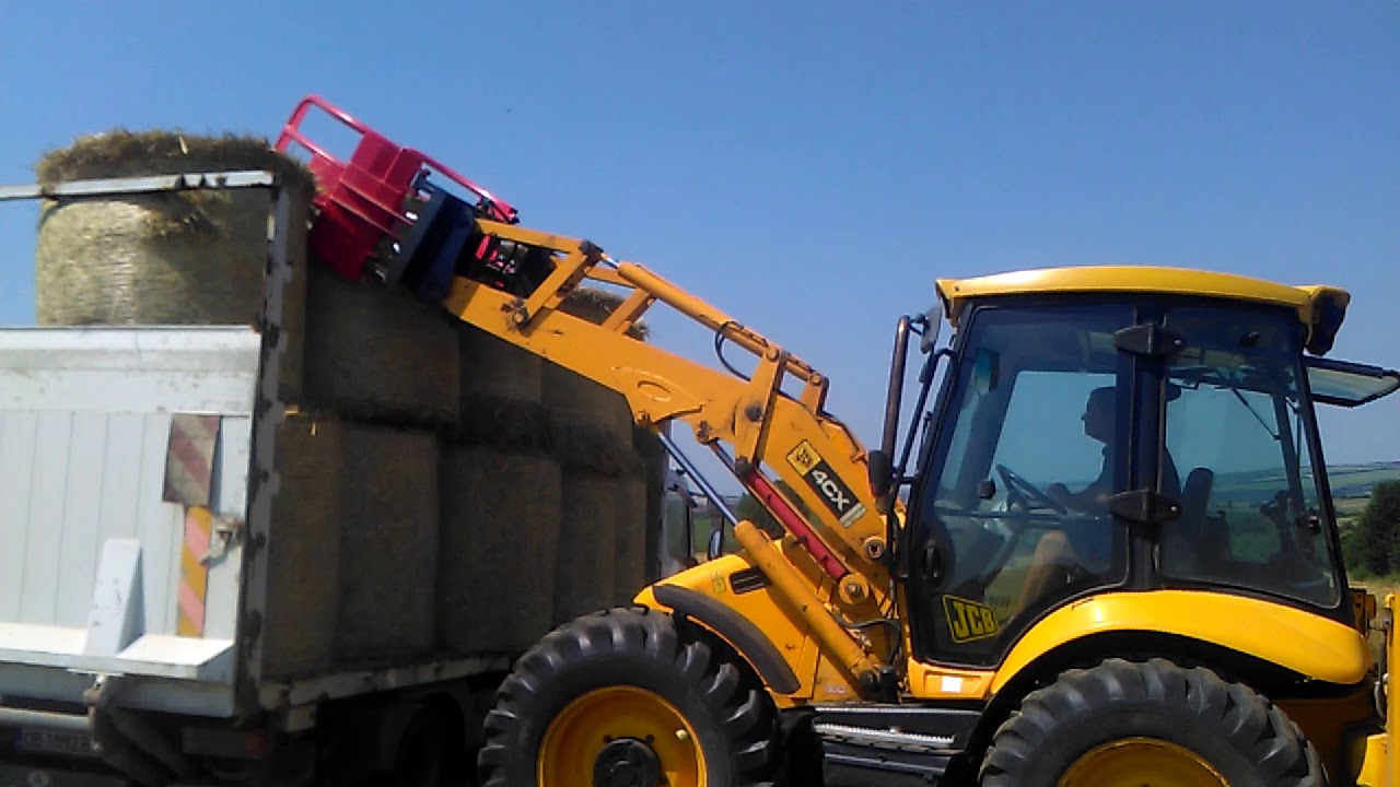 JCB 4CX round bales loading with bale grab. Bulgaria.