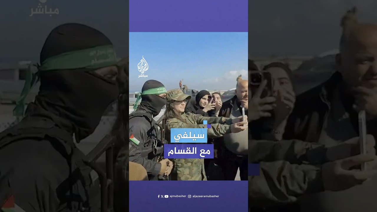 فتاة غزية تتوشح بالزي العسكري وتلتقط صورا تذكارية مع مقاتلي القسام
