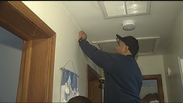 Red Cross volunteers, firefighters install smoke detectors in houses