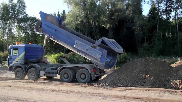 117 116 A dump truck unloading sand and soil; house