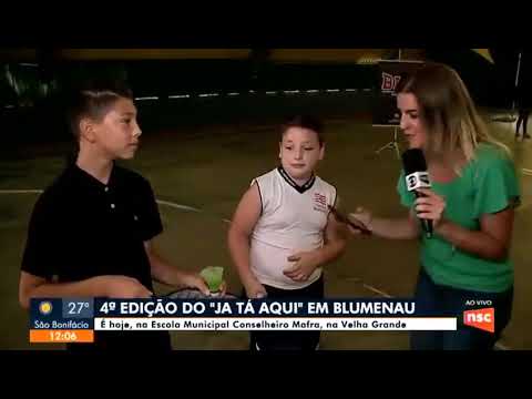 Menino tentando jogar peteca no jornal ao vivo