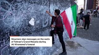 Mourners sign messages on walls during Khamenei funeral
