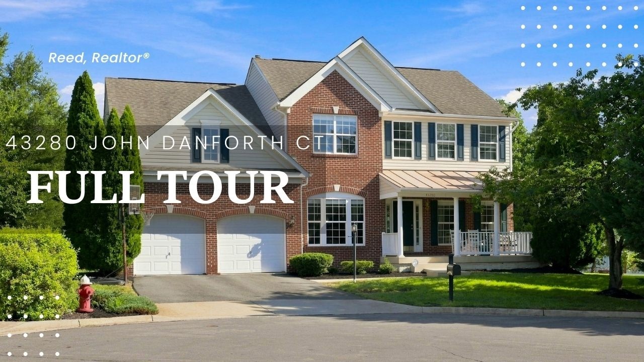 Brick front elevation and two-car garage of a 2004 colonial in Cedar Ridge, Ashburn VA, with a driveway basketball hoop