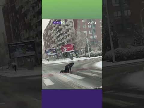 الثلوج تدفع رجلا إلى الزحف لعبور ممر المشاة في مقدونيا الشمالية