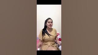 BEAUTIFUL MOTHER WEARING A YELLOW DRESS, SITTING RELAXED WHILE ENJOYING MUSIC