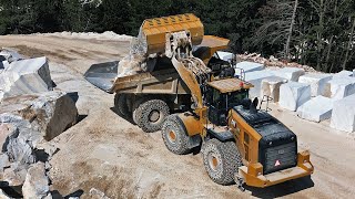CAT 980 wheel loader loading CAT 770 dump truck in marble quarry.