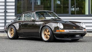 1990 Porsche 911 Singer Reimagined Classic Study Indy Commission - Dixon Bronze - Walkaround (4K)
Key Points: Indy Commission, Reimagined By Singer in July 2022, Rear Wheel Drive Example, 4.0 Litre Porsche Motorsport Built Motor, 6-Speed Manual Gearbox, Electric Sliding Sunroof.
The Porsche 911 (964) Reimagined by Singer represents the ultimate expression of Porsche’s iconic air-cooled sports car, combining the timeless character of the 964-generation 911 with modern engineering, materials and craftsmanship. Reimagined by Singer in July 2022, this left-hand-drive example was commissioned as a “Classic Study” Indy Commission and benefits from an exceptionally detailed specification, including a Porsche Motorsport naturally aspirated 4.0-litre air-cooled flat-six and six-speed manual transmission.
At its heart is Singer’s extensively re-engineered 4.0-litre naturally aspirated flat-six, built by Porsche Motorsport and paired with a six-speed manual gearbox driving the rear wheels. The air-cooled engine retains the character and mechanical purity of Porsche’s classic flat-six while benefiting from modern engineering and performance, making it one of the defining features of the Singer driving experience.
The exterior is finished in distinctive Dixon Bronze, complemented by 17-inch five-spoke Fuchs-style wheels finished in Gold Metallic and Black-painted brake calipers with Gold lettering. Further bespoke details include Dixon Bronze rear bumperettes, a Black Ceramic exhaust finish, brass badging and an electric sliding sunroof. The engine bay is finished with Diamond Quilted Desert Tortoise leather, carbon-fibre rear engine covers and a ceramic-finished plenum, demonstrating the level of attention applied throughout the build.
Inside, the cabin combines Espresso and Desert Tortoise leather with Shug Connolly Nubuck across the dashboard, door panels, rear seats and upper rear compartment. The transmission tunnel, sills and lower rear compartment are finished in Desert Tortoise leather, while lightweight carbon-fibre track seats feature perforated Nubuck centres and exterior-matched Dixon Bronze seat backs.
Reimagined by Singer in July 2022, this Porsche 911 (964) Classic Study Indy Commission showcases the philosophy that has established Singer Vehicle Design as one of the most celebrated names in modern Porsche restoration and reimagination. Combining a Porsche Motorsport-built naturally aspirated 4.0-litre engine, rear-wheel drive, six-speed manual transmission and an entirely bespoke interior and exterior specification, it represents a highly desirable interpretation of the air-cooled Porsche 911. 1990 Porsche 911 Singer Reimagined Classic Study Indy Commission - Dixon Bronze - Walkaround (4K)