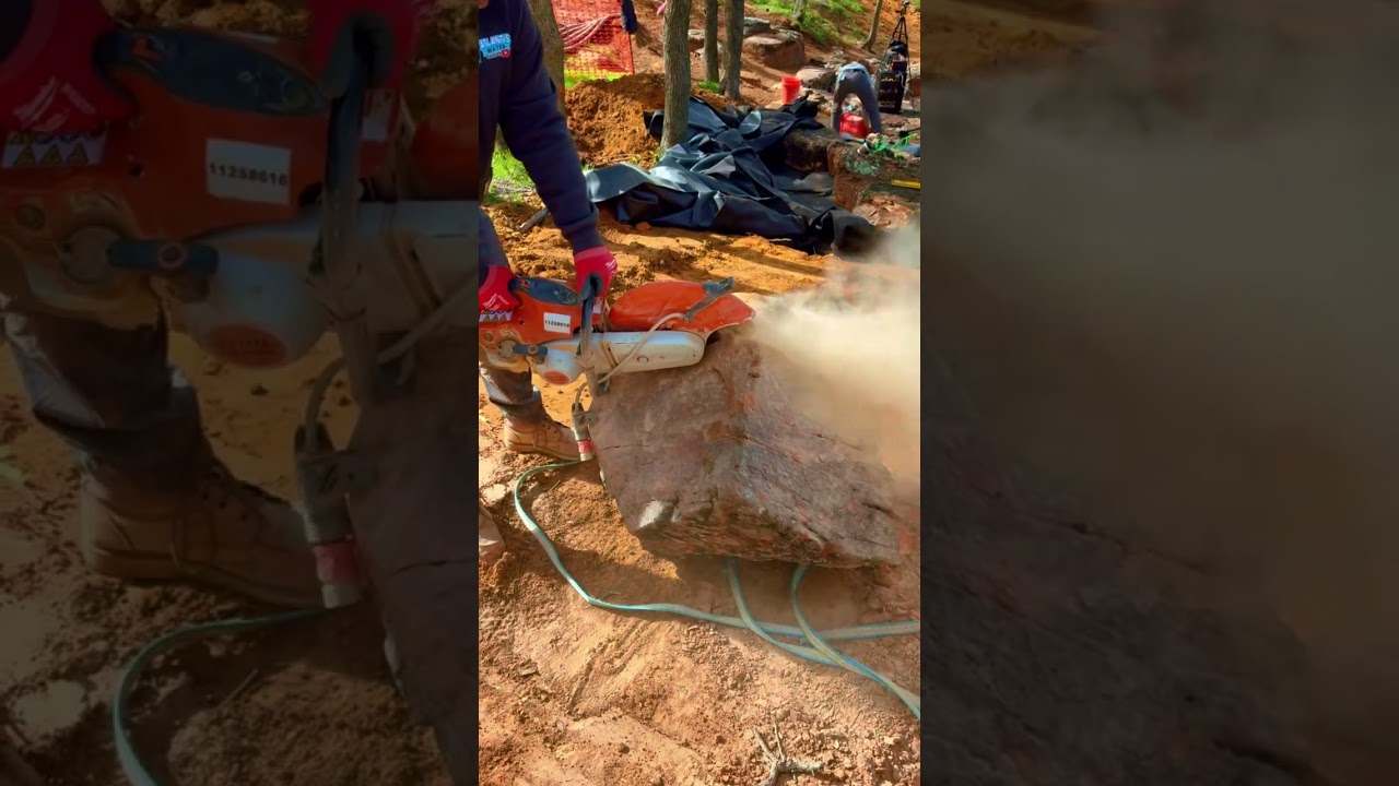 Hand chiseling boulders so they fit perfectly. #diy #watergarden