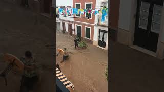 Two people rescue table and plant from flood waters in Es Mercadal, Menorca