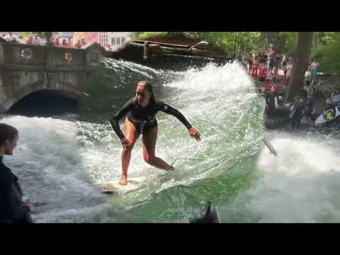 The surfers on the Eisbach wave at the English Garden - Munich 2023 - Germany