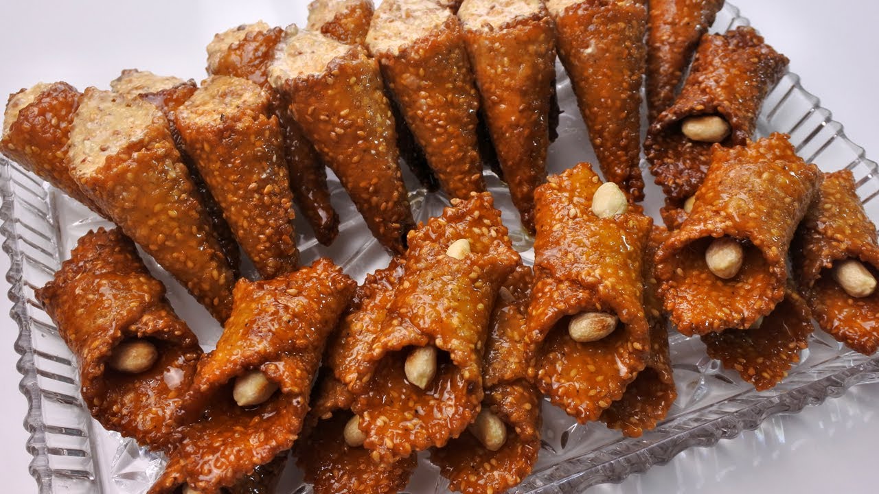 حلوة معسلة مقلية بشكلين كورني محشي والبليغة بكمية وفيرة بالجلجلان مقرمشة ومعسلة بطريقة سهلة اقتصادية