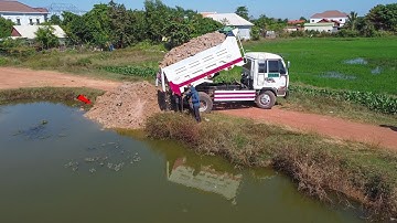 Delete the pond operator skill dump truck with mini bulldozer pushing soil clearing water