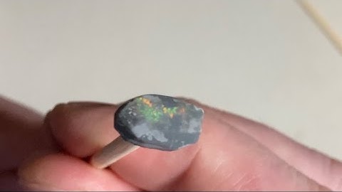 Applying a dop stick to an Australian opal with super glue for easier gem shaping and polishing.