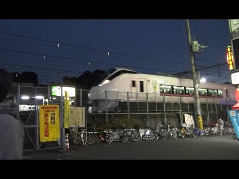 夜の鶯谷駅の北口広場前を通過していく上野東京ライン常磐線特急ひたちE657系のラッピング列車