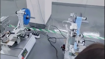 Tabletop tamp labeling machine with robotic arm