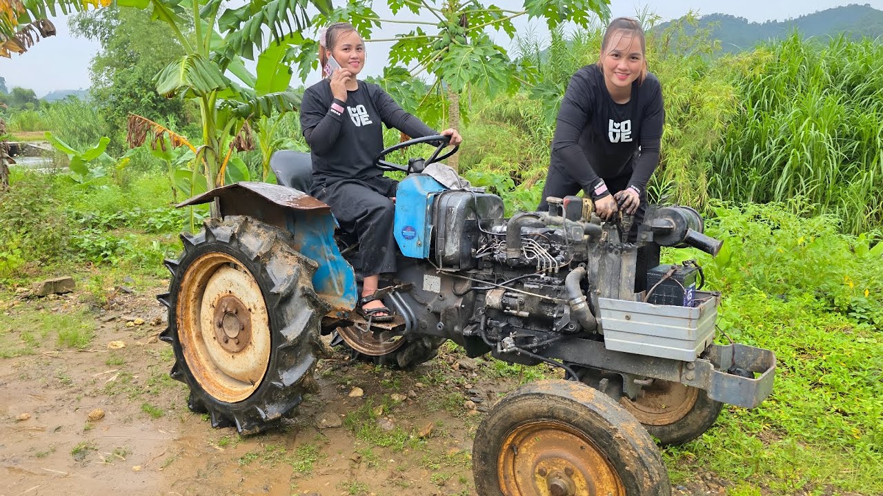 The girl repaired and restored the old tractor was broken for the neighbor.