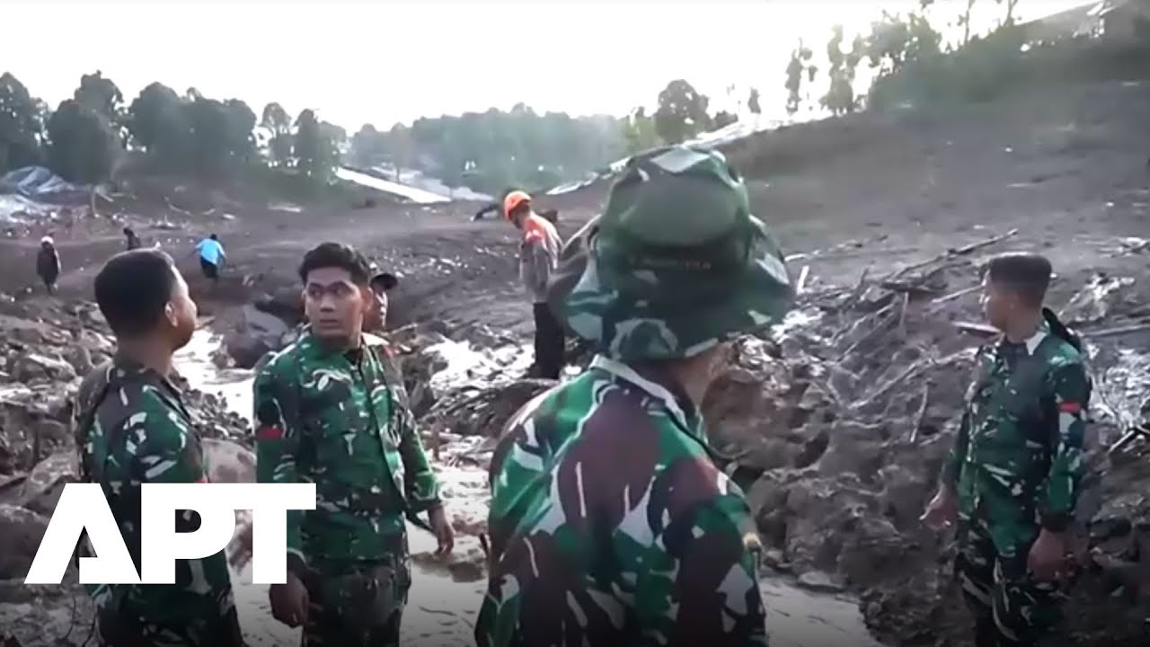 Спасательные команды разбирают грязь после оползня в Индонезии, в результате которого десятки чел...