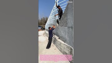 Construction teamwork workers place greenhouse steel frame into preset wall