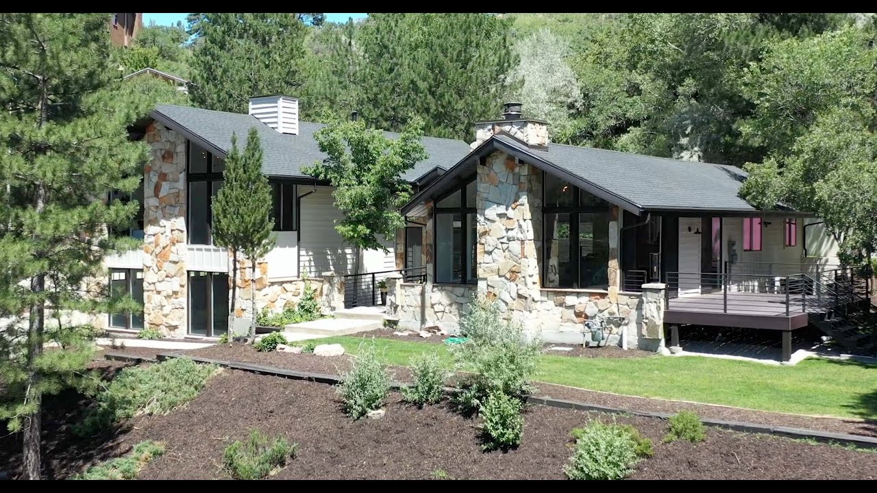 Modern stone and wood house exterior with landscaped yard, showcasing real estate potential for marketing and virtual tours.