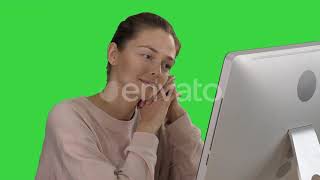 Blonde Girl with Pink Pullover Looking at Monitor of Computer Watching Video on a Green Screen |...