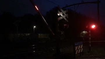 2 treinen komen langs bij Overweg Breda-Prinsenbeek in de avond