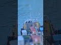 Tugboats Guiding Supply Boat Out Of The River Surrounded By Yachts