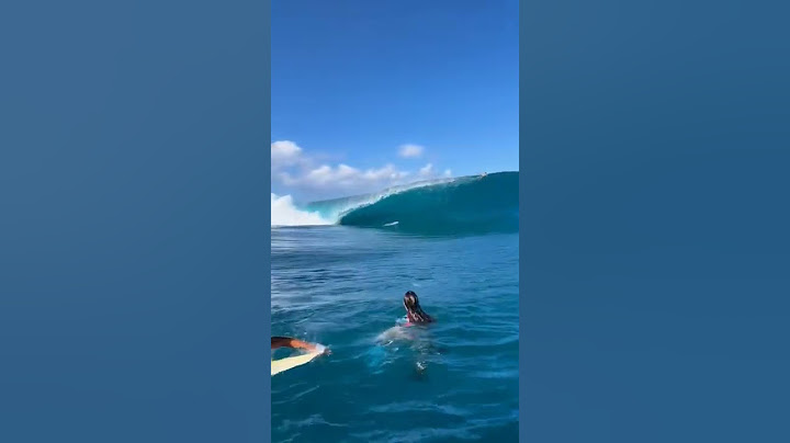 Onda gigante pegando surfista.