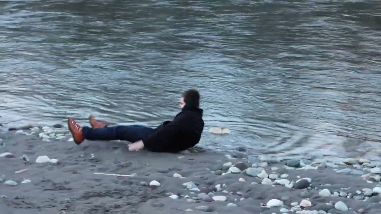 Guy throws log into water and accidentally hits himself on back of head