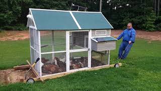 This shows the finished TSC XL Big Green chicken coop on skids with wheels being pulled by hand. I