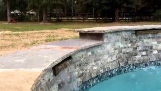 Raised bond beam with scuppers and hand chiseled flagstone coping