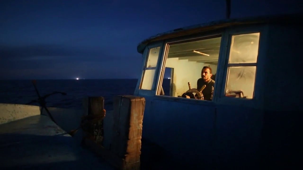 Palestinian fisherman enjoying listening to songs while he's sailing in Gaza sea.