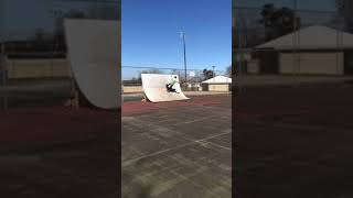 Skateboarder does rock to fakie on quarter pipe at skate park then trucks gets stuck on spine