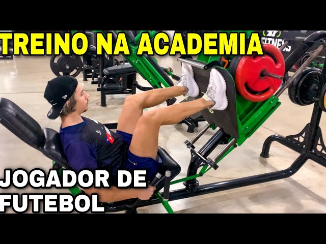 Dois jogadores de futebol fazendo exercícios de alongamento no campo.  treinamento de futebol em estádio ao ar livre, treino em equipe antes do  jogo