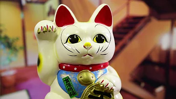 O que está escrito na placa do Maneki Neko?