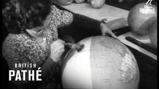 Globe making. Willesden, North West London. A man puts wet paper ar...