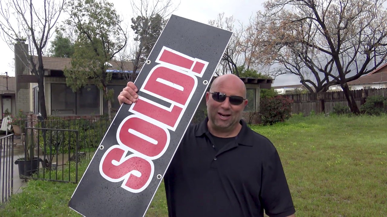 Rex with a sold sign