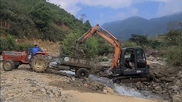 Cầu Khe Trang.Dân bản tạm nghỉ, máy xúc và tractor liên hoàn chở cấp phối đổ đường dẫn phía mố 2