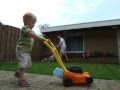 Cute little lawn mower boy is helping his dad