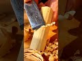 Shaving thin layers of wood from a small block with a sharp chisel for a precision finish