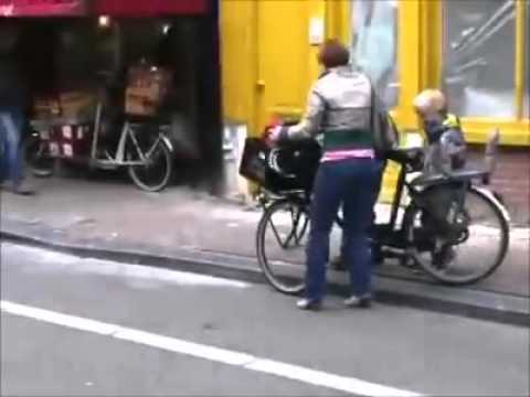 Dutch woman on bicycle with 3 kids