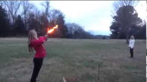Girl lights bonfire with flaming arrow