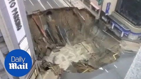 Video shows moment huge sinkhole swallows up a four-lane road - Daily Mail