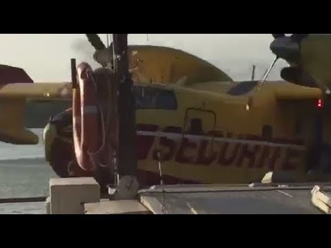 A French Canadair CL-415 water bomber hits a barge after scooping