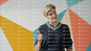 Beautiful adult woman showing thumbs-up gesture smiling happily indoors