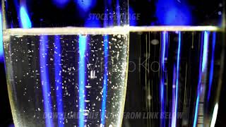 Macro footage of two glasses with champagne on blur illumination background