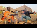 African mum cooking traditional meal to the son village life