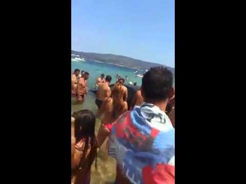 Makina del nga rruga dhe kalon mbi kokat e turistëve në plazh (Video)